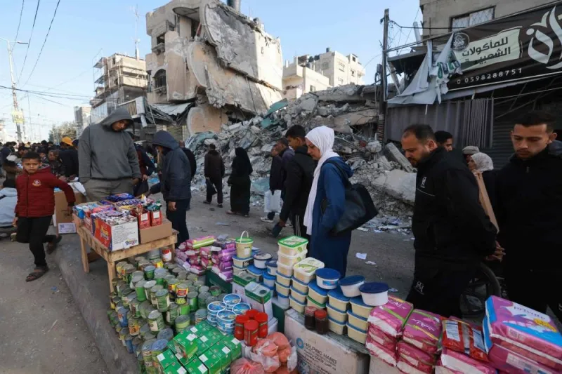Palestinians walk past stalls set up in a street in Rafah