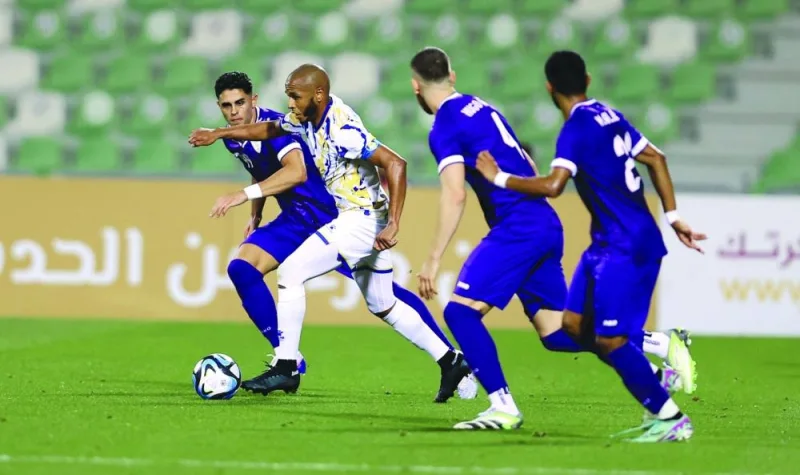 Al Gharafa captain Yacine Brahimi vying for the ball with Muaither players in their Expo Stars League match at the Hamad Bin Khalifa Stadium on Monday.