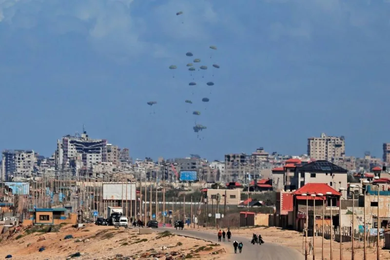 Parachutes attached to parcels of humanitarian aid are airdropped over Gaza City on Friday. AFP