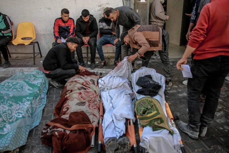 Palestinians identify relatives killed in Israeli bombardment in front of the morgue of the Al-Shifa hospital in Gaza City on Friday. AFP
