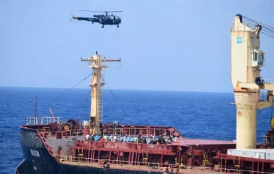 People on board of the recaptured Maltese ship the MV Ruen, as an Indian Naval helicopter flies overhead. AFP/ INDIAN NAVY