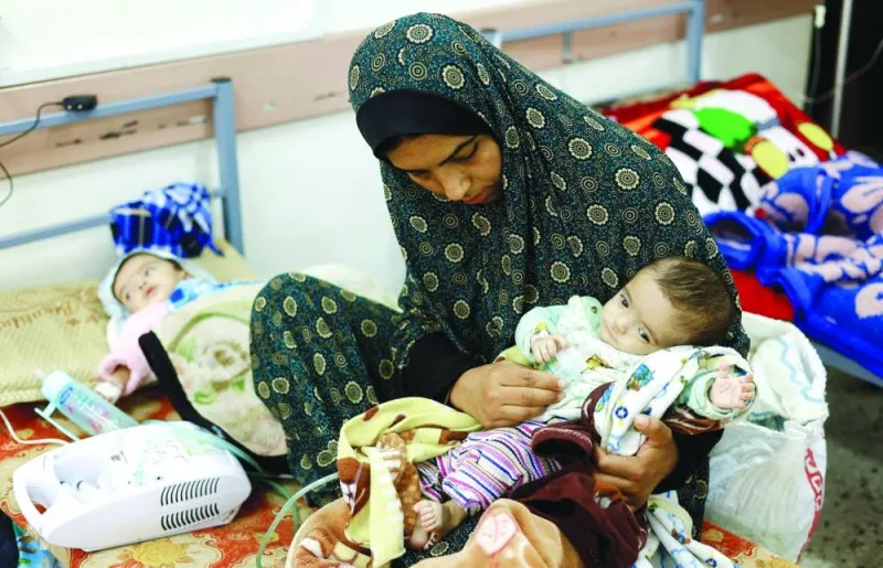 
Palestinian woman Wafaa Tabasi holds her twin malnourished daughter Sameera, at Al-Awda health centre in Rafah in the southern Gaza Strip. 