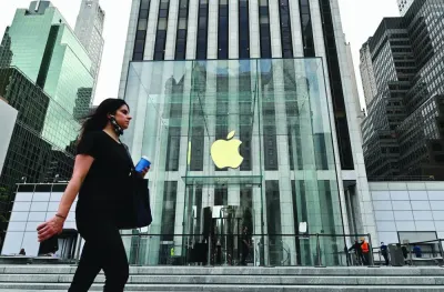 A person walks past the Apple store on Fifth Avenue in New York City. Apple shares fell the most since August on Thursday, after the Justice Department filed a suit accusing Apple of violating antitrust laws and suppressing competition by blocking rivals from accessing hardware and software features on its popular devices.