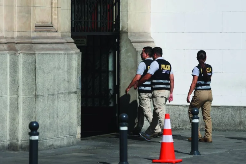 Police officers walk outside the Government Palace (right) after prosecutors raided home of President Dina Boluarte  as part of inquiries into possible illicit enrichment and failure to declare ownership of luxury watches in Lima yesterday. (Reuters)