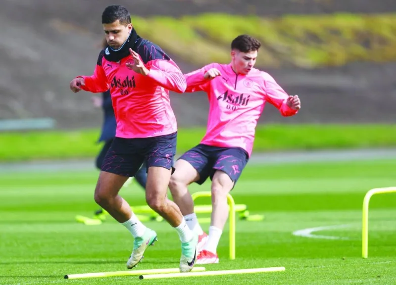 Manchester City’s Rodri (left) and Julian Alvarez take part in a training session on the eve of their champions league quarter-final first leg match against Real Madrid. (AFP)