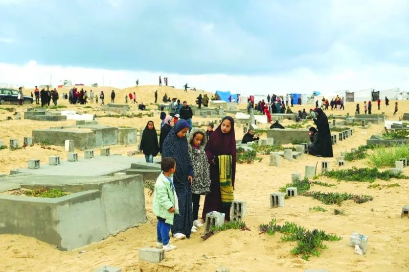 Palestinians visit the graves of loved ones at the start of the Eid al-Fitr festival, at a cemetery in Rafah in the southern Gaza Strip.