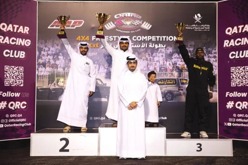 
The winners of the fourth round of the Qatar 4X4 Freestyle Drifting Championship celebrate on the podium with the club’s director Sheikh Jabor bin Khalid al-Thani. 