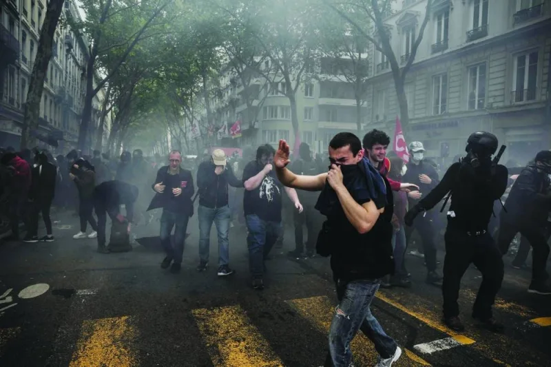 
Union members march towards Taksim Square during a May Day (Labour Day) rally, marking International Workers’ Day, in Istanbul, yesterday. Below: Protesters escape tear gas during a May Day (Labour Day) rally, marking International Workers’ Day, in Lyon, central-eastern France, yesterday. 