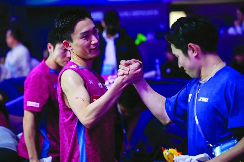 Japan’s Kento Momota shakes hands with his teammate after the doubles quarter-final against Malaysia at the Thomas and Uber Cup badminton tournament in Chengdu, China, on Thursday. (AFP)