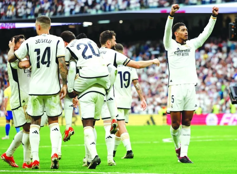 Real Madrid’s midfielder Jude Bellingham (right) celebrates with teammates after scoring a goal during the La Liga match against Cadiz CF at the Santiago Bernabeu stadium in Madrid on Saturday. (AFP)