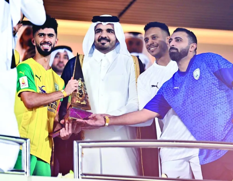 Qatar Olympic Committee President HE Sheikh Joaan bin Hamad al-Thani presents the Qatar Cup to Al Wakrah coach Ali Rahma 
al-Marri and midfielder Ahmed Fadhil Hesaba on Saturday. PICTURES: Noushad Thekkayil