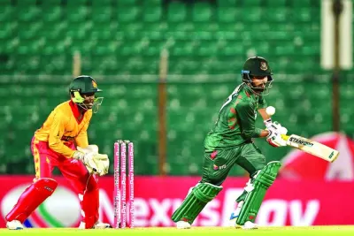 
Bangladesh’s Towhid Hridoy plays a shot as Zimbabwe’s wicketkeeper Joylord Gumbie looks on during the second Twenty20 international in Chittagong yesterday. (AFP) 