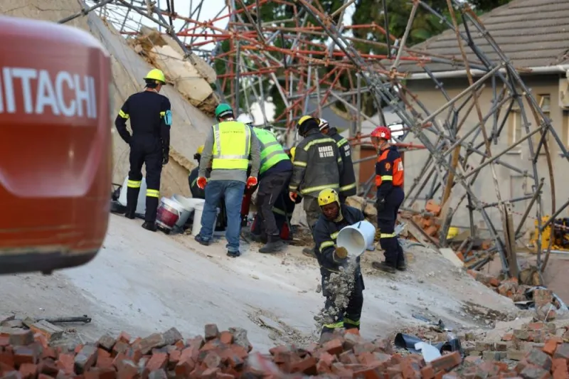 A rescue worker removes rubble from the site where construction workers are trapped under a building that collapsed in George, South Africa May 7, 2024.