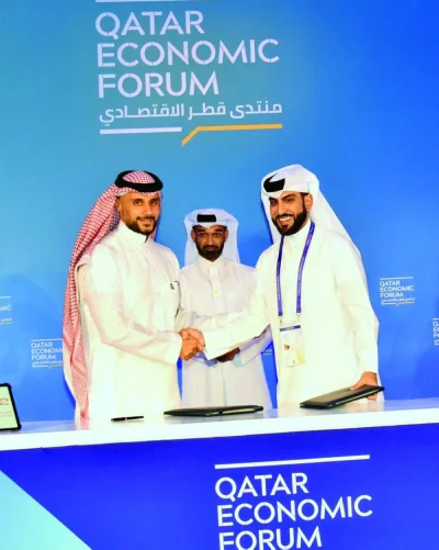 Prince Khaled bin Alwaleed bin Talal al-Saud (left) and Nasser al-Khori shake hands at the MoU signing on the sidelines of QEF 2024 as HE Hassan al-Thawadi looks on,