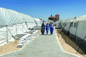 People walk at the International Red Cross field hospital in southern Gaza, which has been set up to try to meet what it described as an 'overwhelming' demand for health services since Israel's military operation on Rafah began last week‏, amid the ongoing conflict in the Al-Mawasi area.
