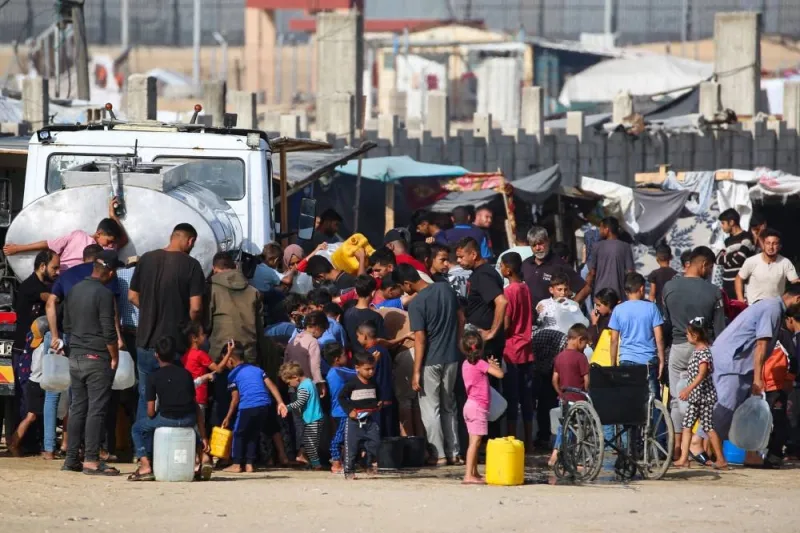 Displaced Palestinians queue to buy water from a water truck next to their temporary camp in Rafah on Friday. AFP