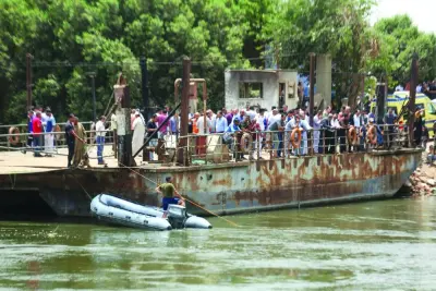 Relatives wait on the bank of a canal of the Nile River as rescuers search the waterway for casualties after a minibus sank near Abu Ghaleb village in Egypt's Giza governorate, yesterday.