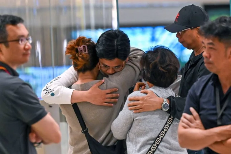 Passengers of Singapore Airlines flight SQ321 from London to Singapore, which made an emergency landing in Bangkok, greet family members upon arrival at Changi Airport in Singapore on Wednesday. AFP