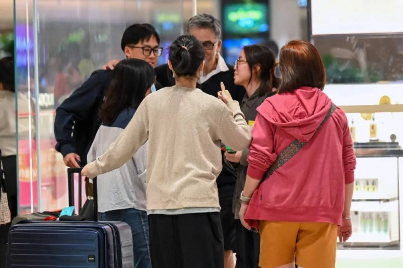 Passengers of Singapore Airlines flight SQ321 from London to Singapore, which made an emergency landing in Bangkok, greet family members upon arrival at Changi Airport in Singapore on Wednesday. AFP