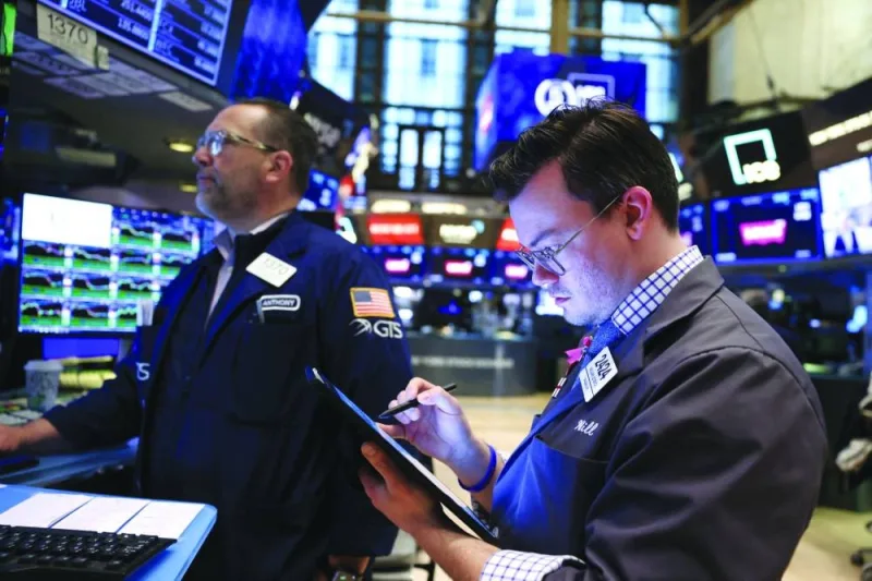 Traders work at the New York Stock Exchange (NYSE). Starting on May 28, US trades will “settle” (complete the exchange of dollars for stock) in one day rather than two. US banks, brokers and investors have been forced to review all of their post-trade technologies and procedures to ensure they are ready for the new pace of stock trading. The change poses a special challenge to investors outside the US who need to buy dollars as part of their stock trades.