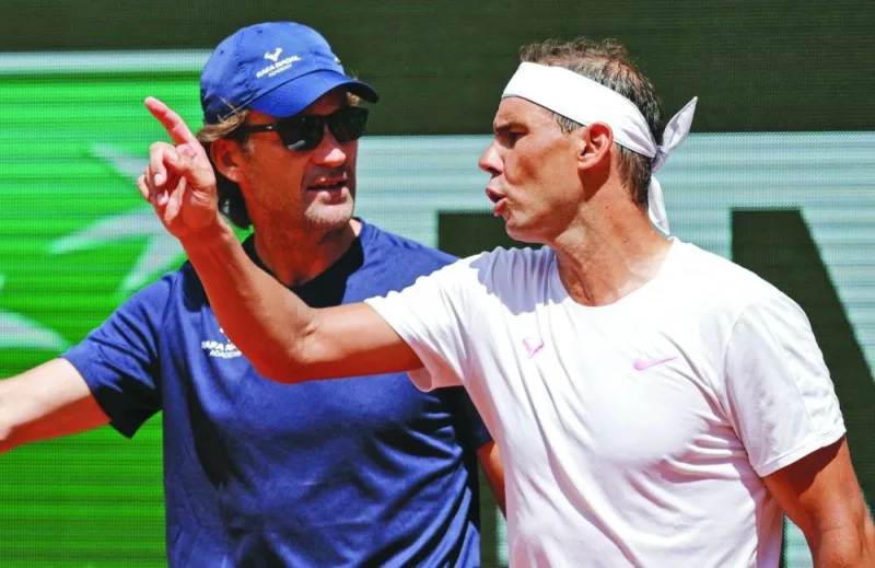 Spain’s Rafael Nadal (right) speaks with his coach Carlos Moya during a practice session on Thursday ahead of the French Open at the Roland Garros Complex in Paris. (AFP)