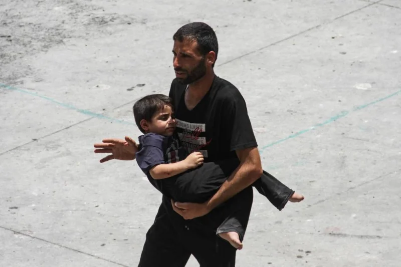 A man carries a child in Gaza City, on Saturday. REUTERS