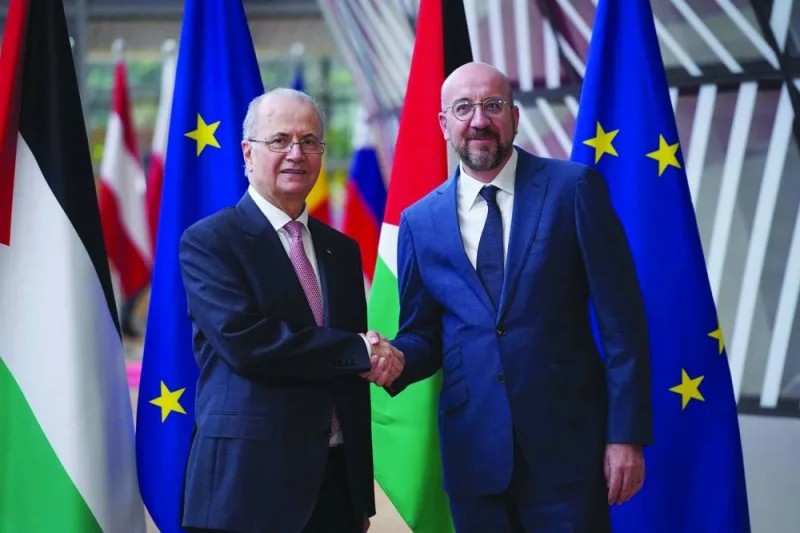 Palestinian Prime Minister Mohamed Mustafa shakes hands with President of the European Council Charles Michel (right) during their meeting at the EU headquarters in Brussels, yesterday.