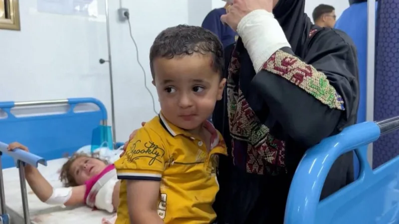A Palestinian woman holds a child as people are assisted at a hospital following an Israeli strike on an area designated for displaced people, as the war in Gaza continues, in Rafah in the southern Gaza Strip, on Sunday, in this screen grab from a video obtained by Reuters.