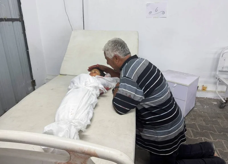 A man reacts next to the body of a Palestinian child killed in an Israeli strike on an area designated for displaced people in Rafah in the southern Gaza Strip, on Sunday. REUTERS