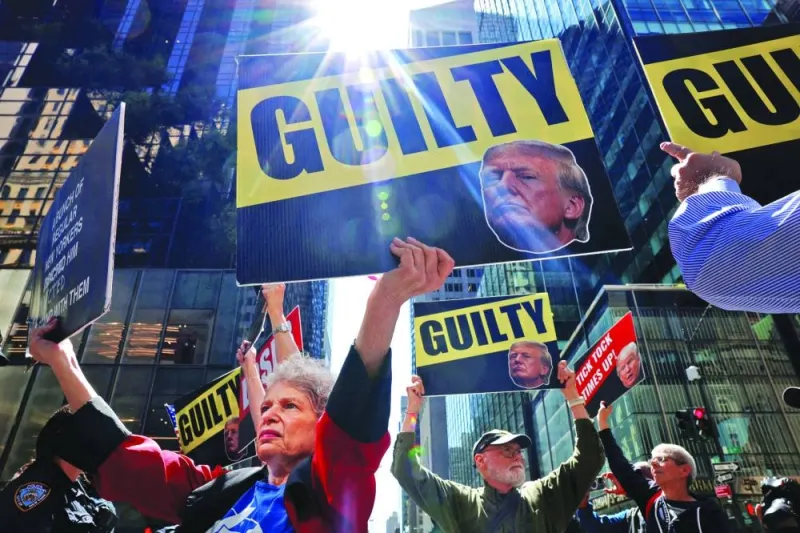 Anti-Trump protesters hold placards outside Trump Tower, the day after a guilty verdict in Republican presidential candidate and former US president Donald Trump’s criminal trial in New York City on Friday.