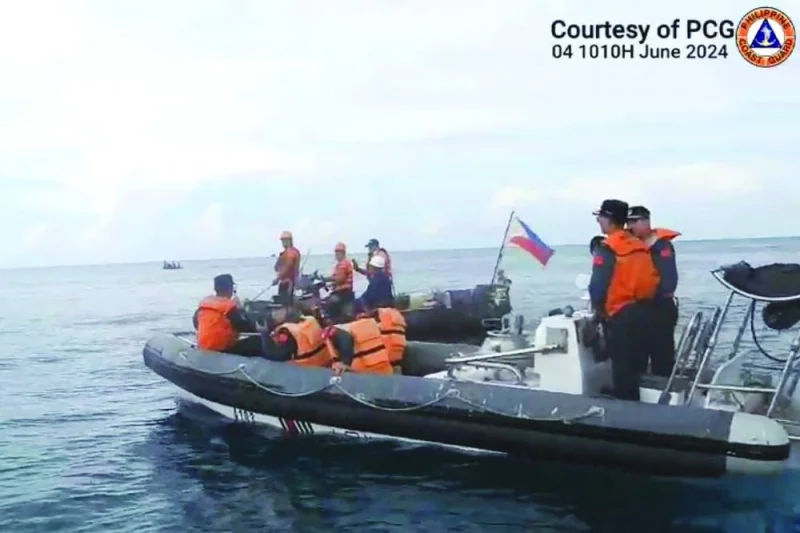 Chinese Coast Guard personnel aboard their rigid inflatable boat, block a Philippine Coast Guard rigid inflatable boat (back) carrying marine scientists in the waters of the South China Sea.