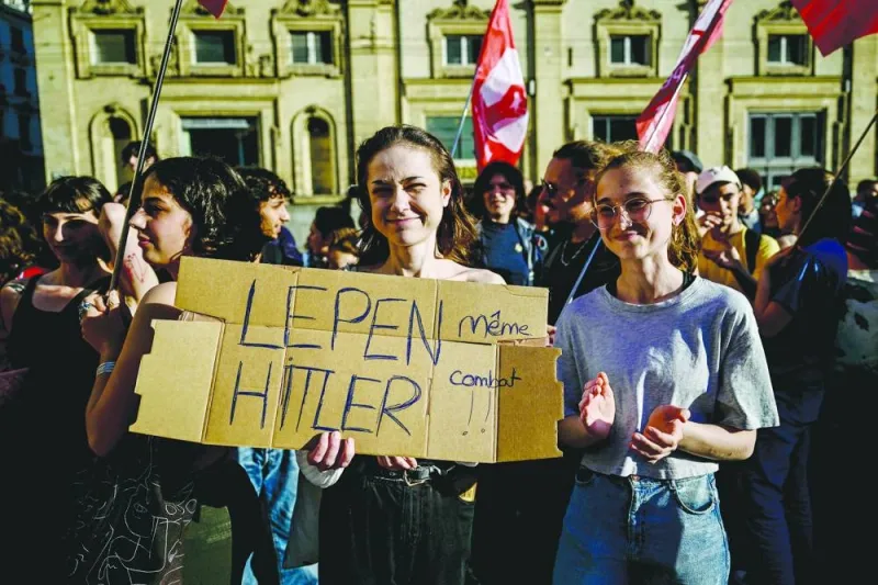 Protestors hold a placard which reads "Le Pen and Hitler, same fight" during a demonstration against the French far-right party Rassemblement National (RN) political party after their success in the European elections, at a rally in Lyon, central eastern France, on Monday.
