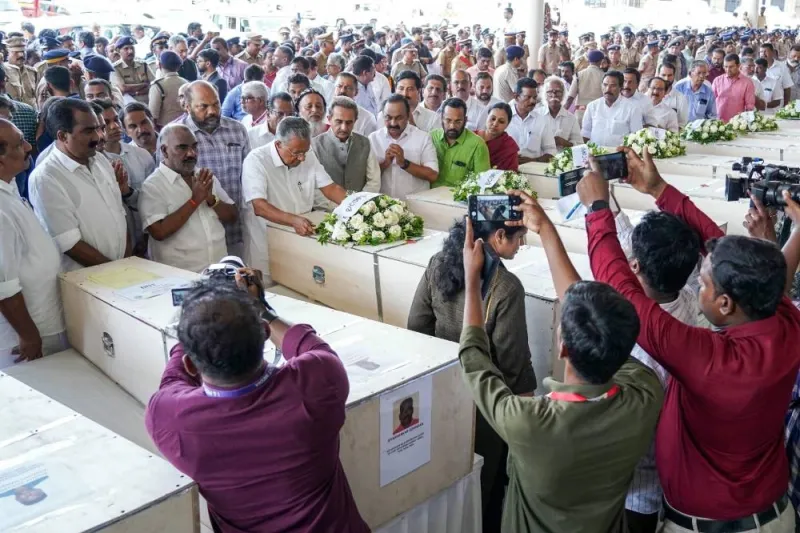 Kerala chief minister Pinarayi Vijayan lays a wreath on the deceased after coffins&#039; arrival on an Indian Air Force plane from Kuwait at the Cochin International Airport in Kochi on Friday. AFP