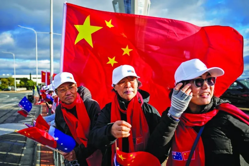 
People wave Chinese national flags as they await the arrival of China’s Premier Li Qiang in Adelaide, Australia.  