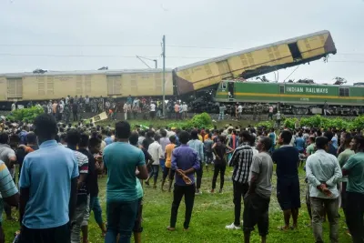 People gather near the site of a collision between a passenger and a goods train in Nirmaljote, near Rangapani station in India's West Bengal yesterday.