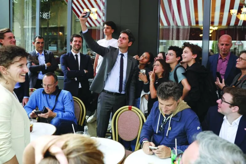 France&#039;s Prime Minister Gabriel Attal (C) takes a selfie with youth next to French MP for the Renaissance group Mathieu Lefevre (3rdL), candidate for his re-election in the 5th constituency of the Val-de-Marne department, as they meet with local residents in Le Perreux-sur-Marne, east of Paris, Monday.
