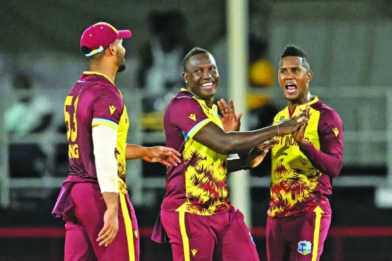 West Indies&#039; Akeal Hosein (right) celebrates after dismissing Afghanistan&#039;s Azmatullah Omarzai (out of frame) with teammates West Indies&#039; Brandon King (left) and captain Rovman Powell (centre) during the ICC Twenty20 World Cup match at Daren Sammy Cricket Ground in Gros Islet, St. Lucia, on Tuesday. (AFP)