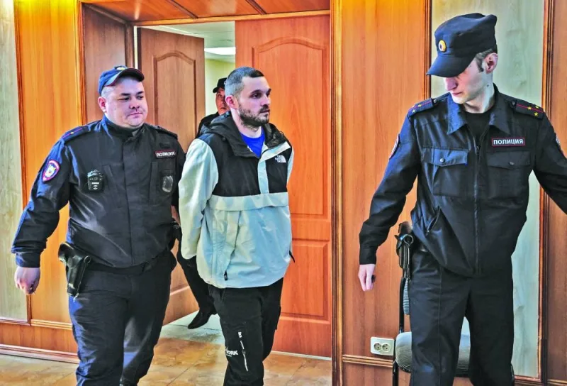 Gordon Black, a US Army staff sergeant, who was detained in Russia on May 2 on suspicion of stealing from a woman, is escorted in a court in Vladivostok, Russia, on Wednesday.