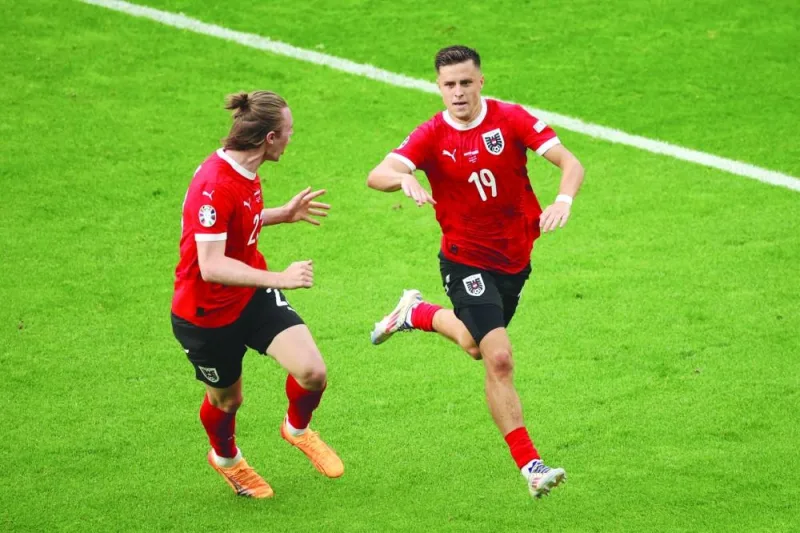 Austria’s midfielder Christoph Baumgartner celebrates with defender Patrick Wimmer after scoring his team’s second goal during the UEFA Euro 2024 Group D match against Poland at the Olympiastadion in Berlin on Friday. (AFP)