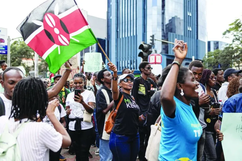 A woman waves a Kenyan flag while marching against the Finance Bill 2024 in downtown Nairobi, yesterday.