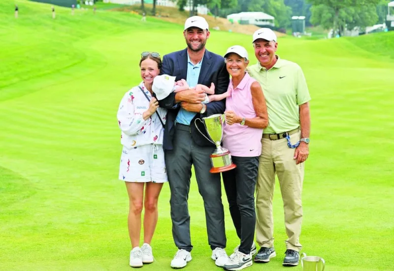 
Scottie Scheffler of the US poses with his wife Meredith, their young son and family after putting in to win on the 18th green during a playoff during the final round of the Travellers Championship at TPC River Highlands in Cromwell, Connecticut. (AFP) 