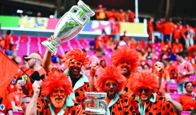 
Dutch fans holding mockup trophies cheer on prior to the UEFA Euro 2024 Group D match between the Netherlands and France at the Leipzig Stadium in Leipzig on June 21, 2024. (AFP) 