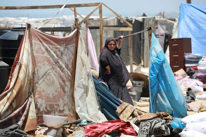 A displaced Palestinian woman stands next to her belongings as people evacuate the Mawassi area on the outskirts of southwestern Khan Yunis in the southern Gaza Strip on Friday. AFP
