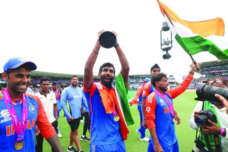 
India’s Jasprit Bumrah celebrates with the trophy along with teammates Suryakumar Yadav (left) and Kuldeep Yadav. (Reuters) 