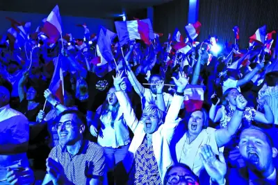 Supporters of National Rally party celebrate after partial results in the first round of the French parliamentary elections, in Henin-Beaumont, France, Sunday.