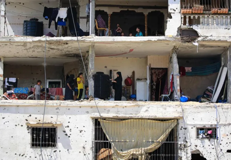 Palestinians families return to their badly damaged homes in an apartment block in Khan Yunis, in the southern Gaza Strip on Sunday. AFP