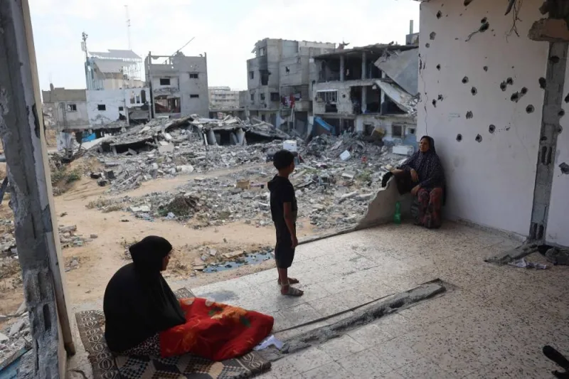 A Palestinian family sits in the remains of their home damaged in previous Israeli bombardment, as some residents return to the city of Khan Yunis, in the southern Gaza Strip on Sunday. AFP