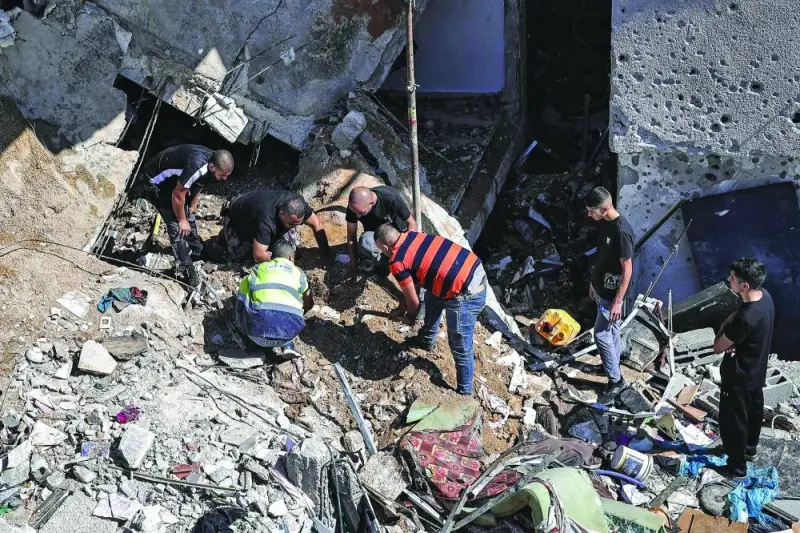 People search the rubble of a building hit by bombardment at the Nur Shams camp for Palestinian refugees, east of Tulkarm in the occupied West Bank, yesterday.