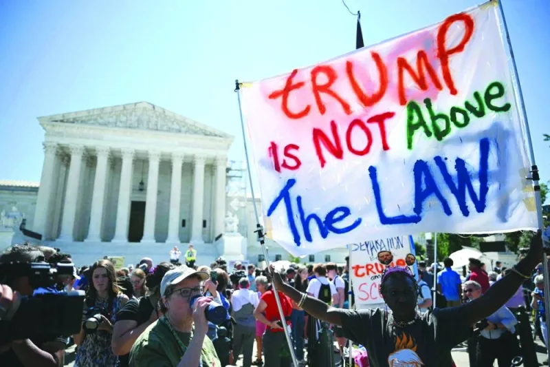 People hold anti-Trump signs in front of the US Supreme Court on Monday in Washington, DC. (AFP)
