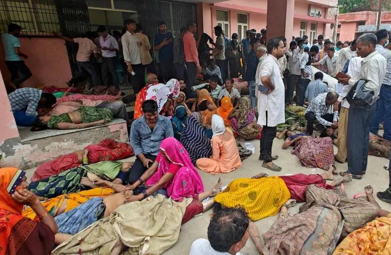 People mourn next to the bodies of victims of a stampede outside a hospital in Hathras, Tuesday. REUTERS